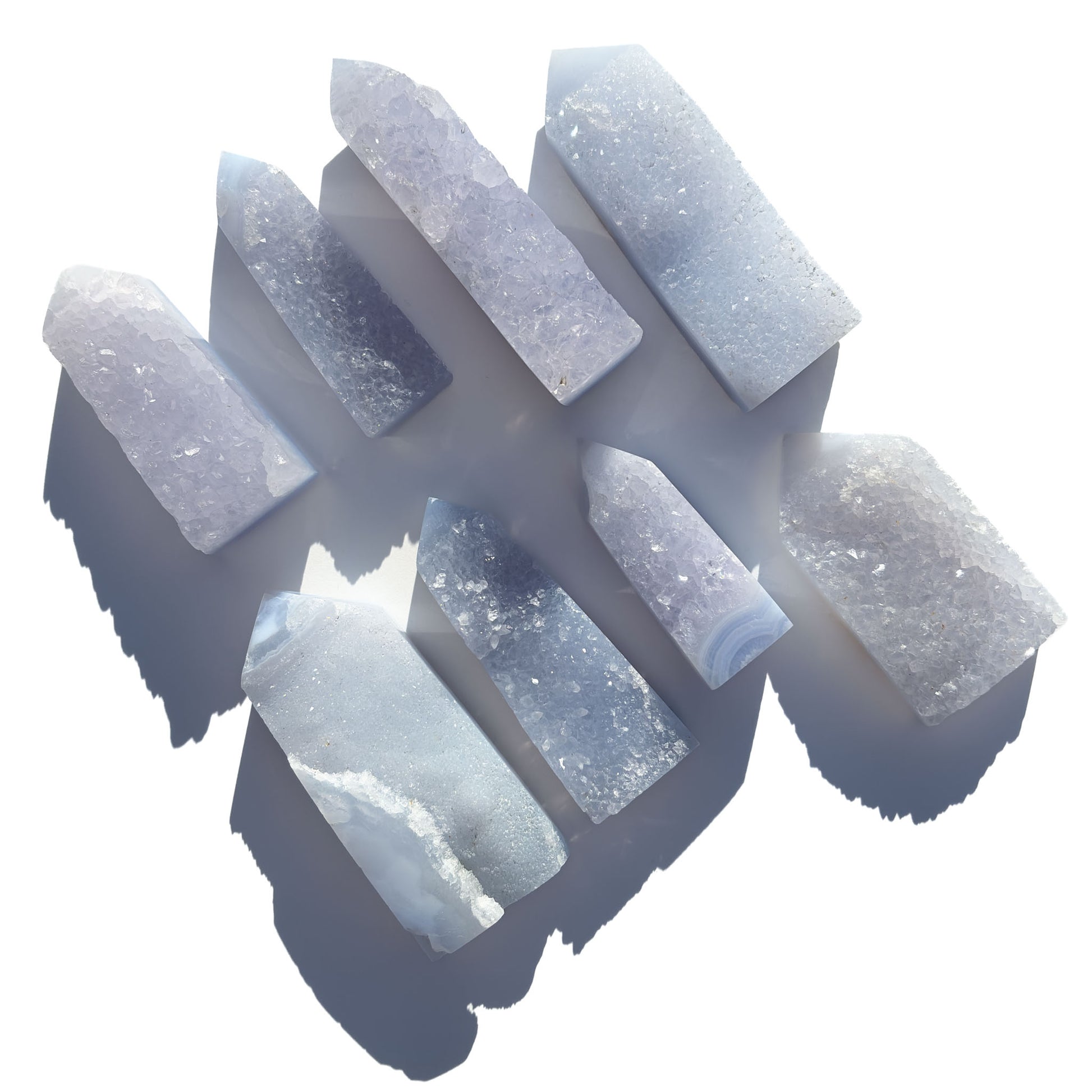 eight blue chalcedony crystal towers on a white background with shadows