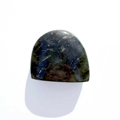 back of labradorite freeform crystal freeform with flash, on a white background with light shadow.