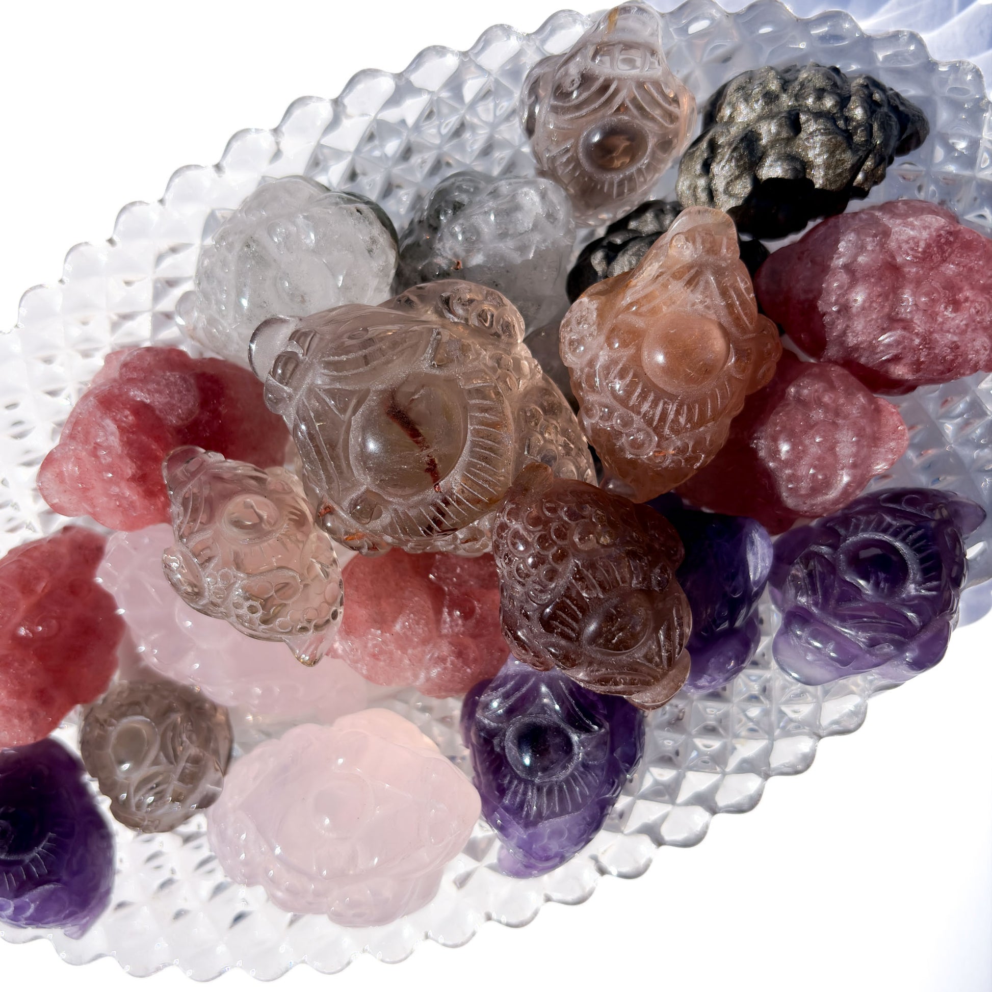 A variety of different crystal Money Toads sitting in a glass dish.