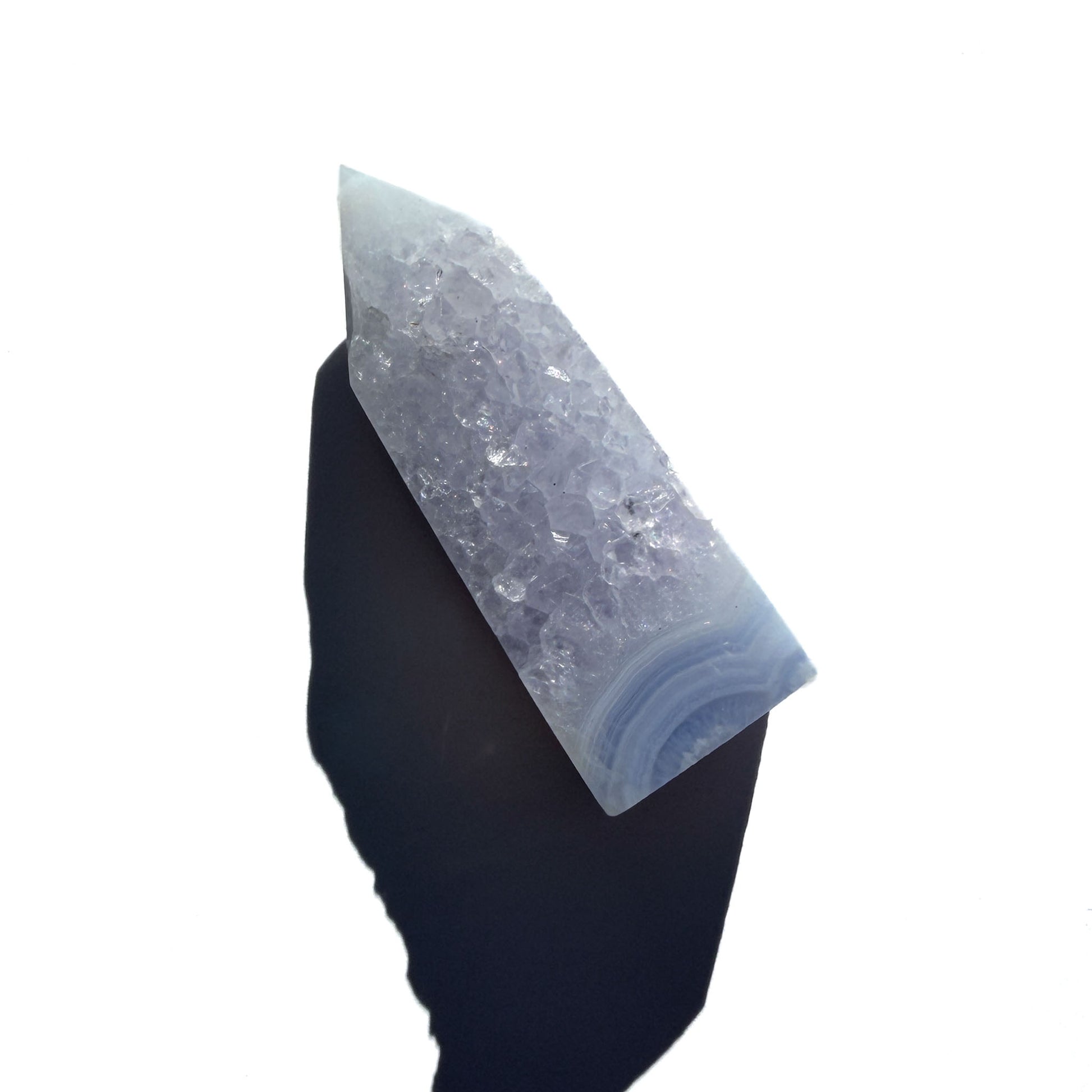 blue chalcedony crystal tower on a white background with shadow.