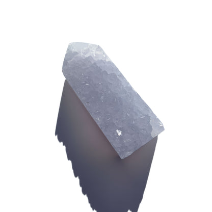 blue chalcedony crystal tower on a white background with shadow.