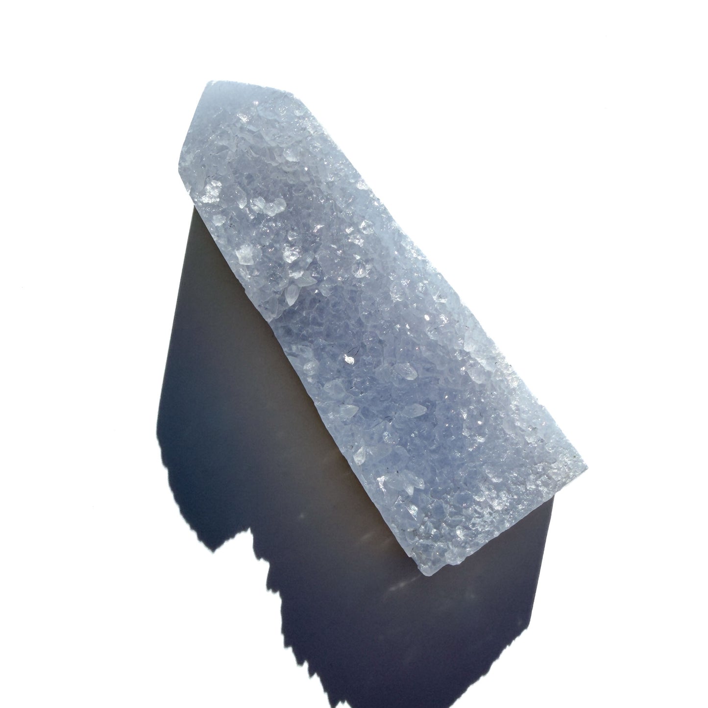 blue chalcedony crystal tower on a white background with shadow.