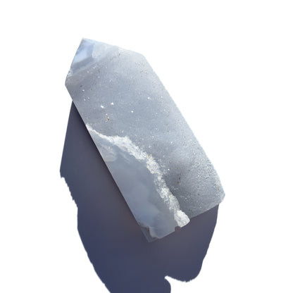blue chalcedony crystal tower on a white background with shadow.